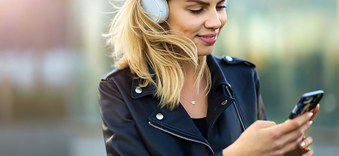 Woman listening to music with her smartphone outside