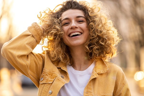 Portrait of young woman with curly hair in the city